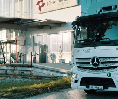 E-Lkw vor einer Ladesäule auf einem Betriebsgelände